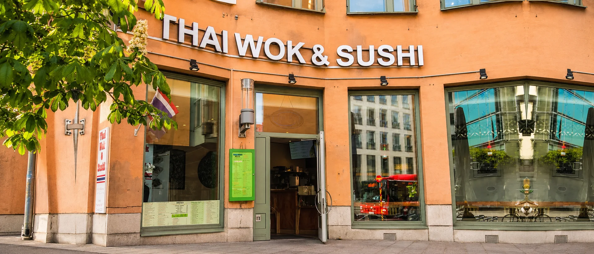 Ja Thai Wok & Sushi på Hornsgatan 22 en sommarkväll, med kastanjeträdet utanför entrén
